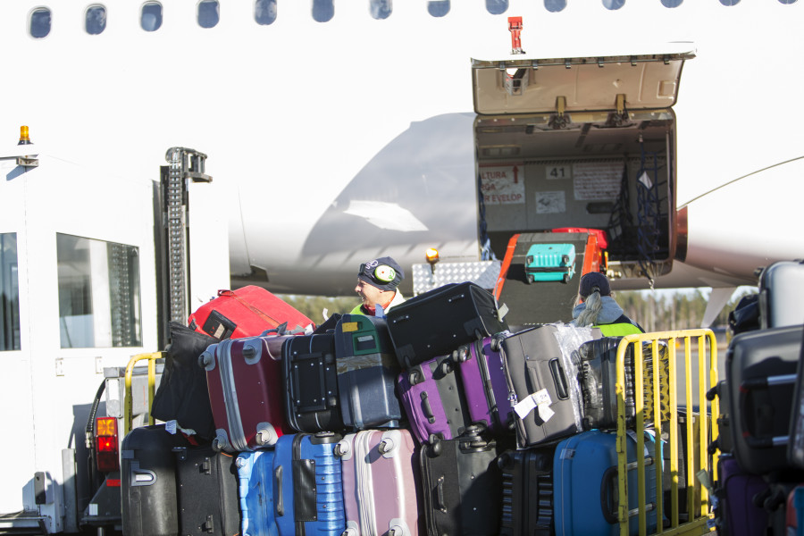 Luggage trolley with bags outside aircraft