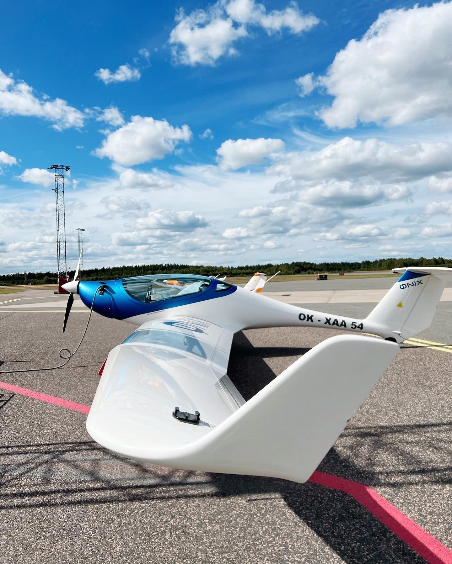 Elflygplan parkerat på uppställningsplats och laddning pågår.