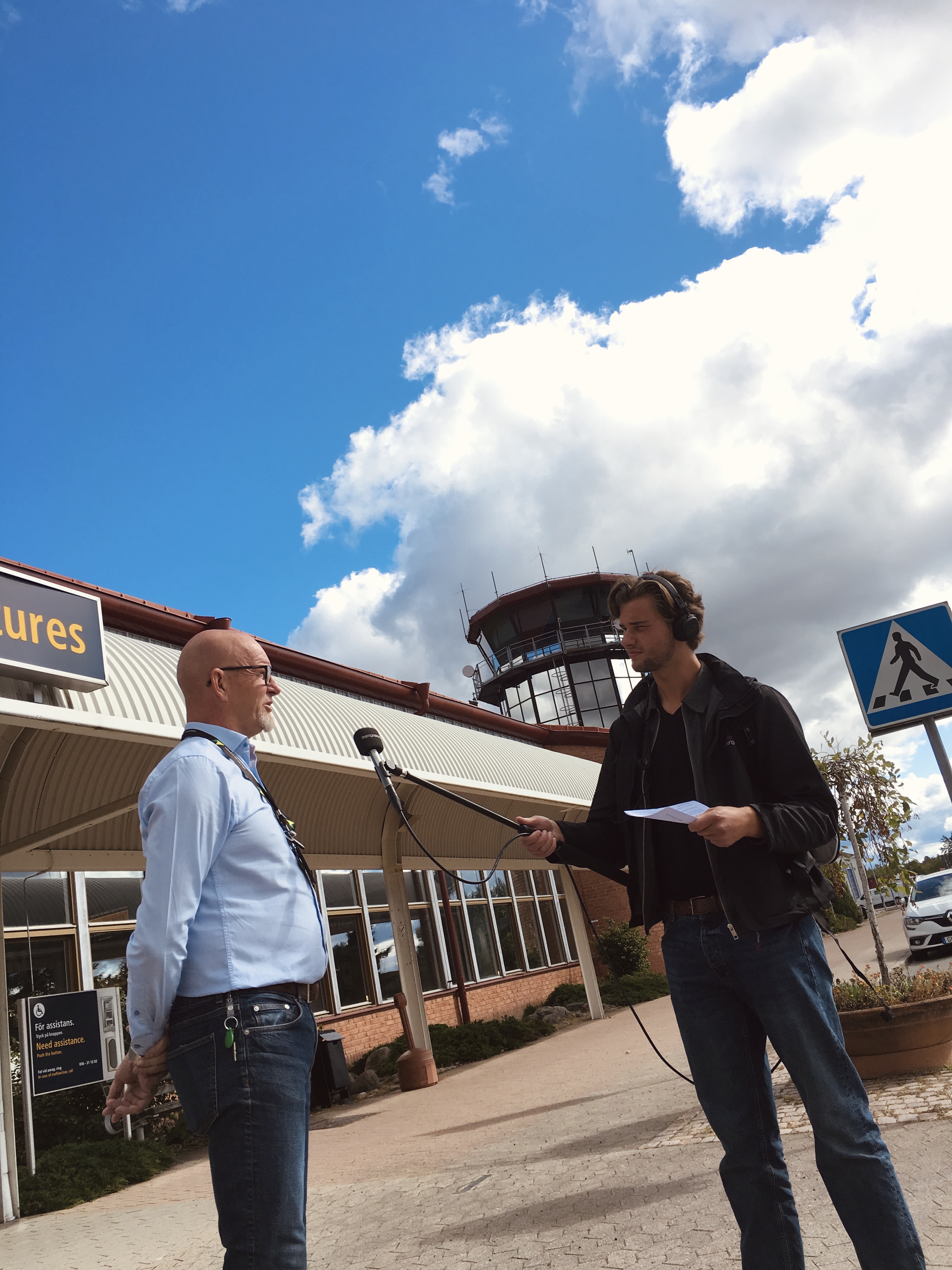 P4 Jönköping intervjuar Rony Forsberg, VD på Jönköping Airport, utanför terminalen med flygledartornet i bakgrunden.
