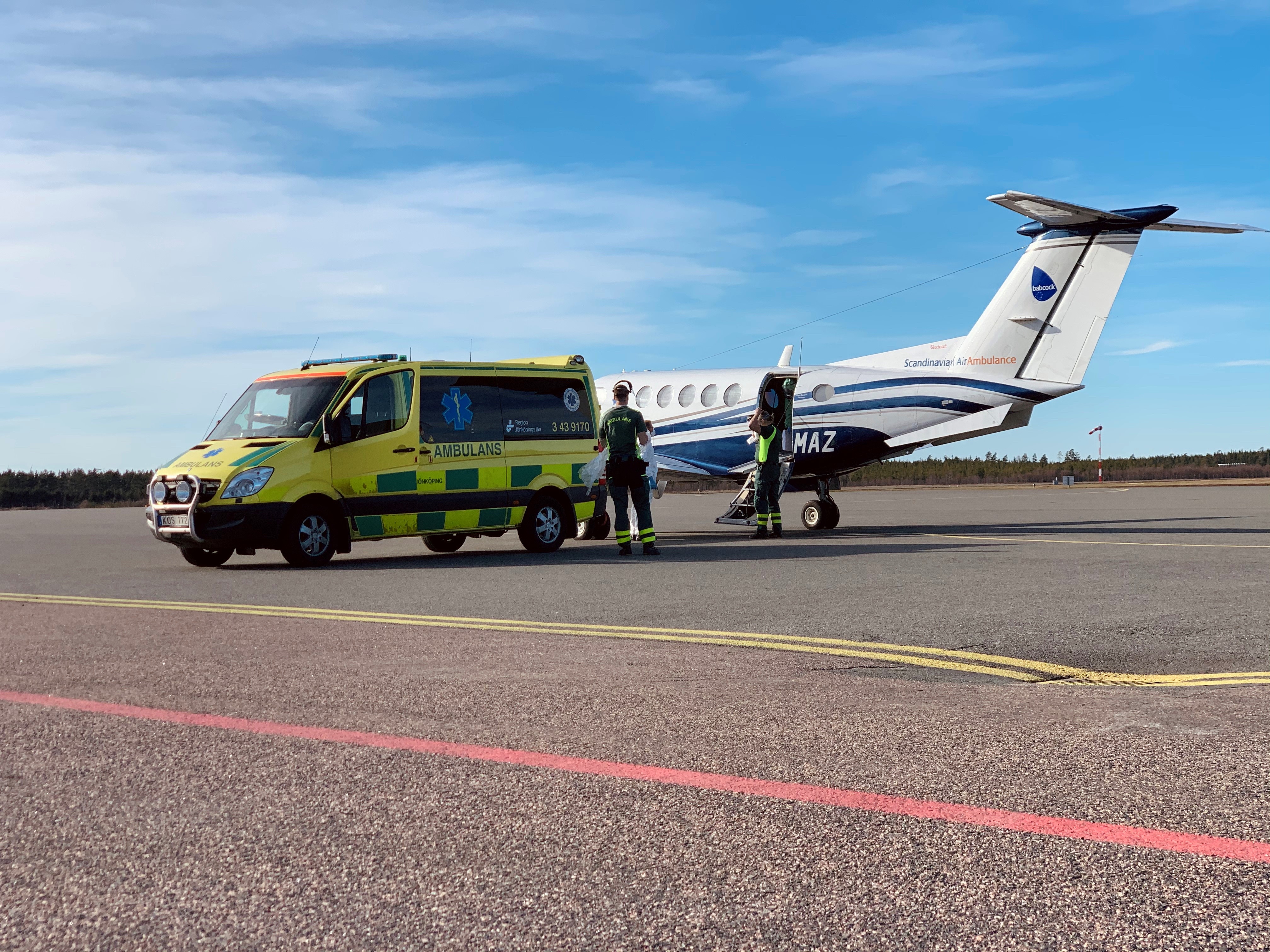 Pågående förflyttning av patient mellan flygplan och ambulans.