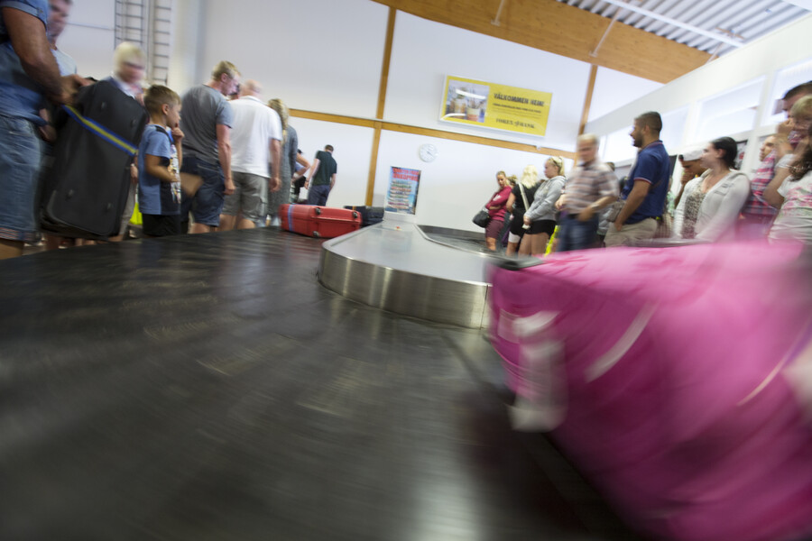 Väskor rullar på ankommande bagageband